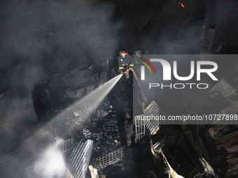 Bangladeshi fire fighters try to extinguish a fire that broke out Baburhat, Narsingdi on October 30, 2023, which is one of the biggest tradi...