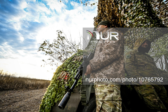 ZAPORIZHZHIA REGION, UKRAINE - NOVEMBER 03, 2023 - Servicemen of the Ukrainian anti-aircraft missile troops stand by the car covered with a...