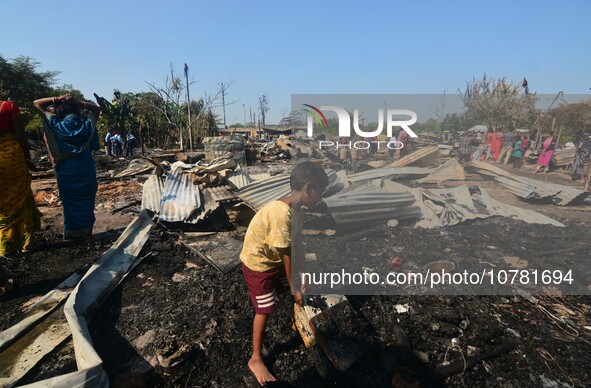 A kid salvage his belonging from a charred place after an inferno on the night of Diwali, the Hindu Festival of Light celebration, which gut...