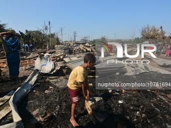 A kid salvage his belonging from a charred place after an inferno on the night of Diwali, the Hindu Festival of Light celebration, which gut...