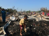 A kid salvage his belonging from a charred place after an inferno on the night of Diwali, the Hindu Festival of Light celebration, which gut...