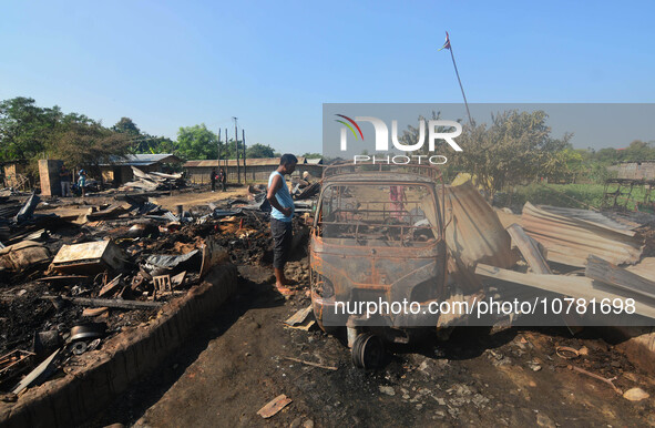 A resident looks at a charred vehicle after an inferno on the night of Diwali, the Hindu Festival of Light celebration, which gutted down at...