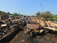 A resident looks at a charred vehicle after an inferno on the night of Diwali, the Hindu Festival of Light celebration, which gutted down at...