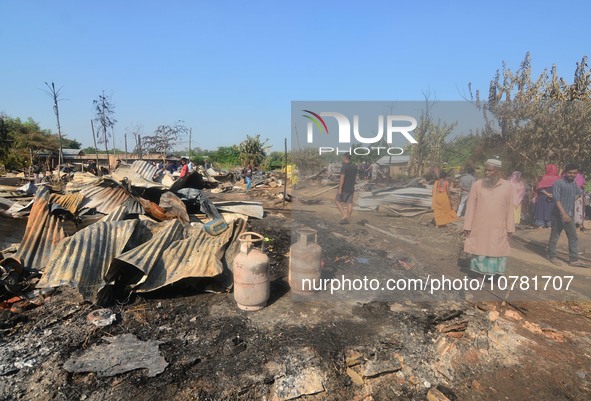 Residents walk pass by their charred house after an inferno on the night of Diwali, the Hindu Festival of Light celebration, which gutted do...