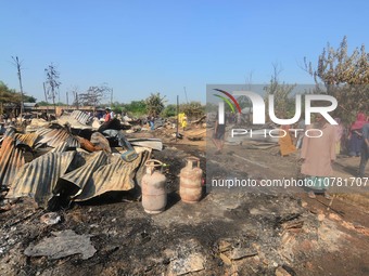 Residents walk pass by their charred house after an inferno on the night of Diwali, the Hindu Festival of Light celebration, which gutted do...