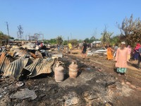 Residents walk pass by their charred house after an inferno on the night of Diwali, the Hindu Festival of Light celebration, which gutted do...