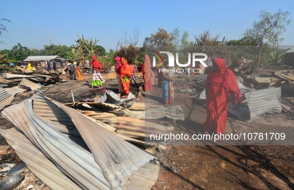 Residents walk pass by their charred house after an inferno on the night of Diwali, the Hindu Festival of Light celebration, which gutted do...