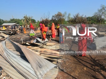 Residents walk pass by their charred house after an inferno on the night of Diwali, the Hindu Festival of Light celebration, which gutted do...