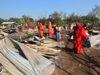 Residents walk pass by their charred house after an inferno on the night of Diwali, the Hindu Festival of Light celebration, which gutted do...