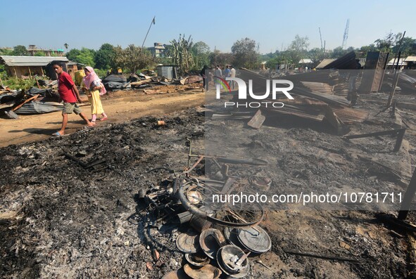 Residents walk pass by their charred house after an inferno on the night of Diwali, the Hindu Festival of Light celebration, which gutted do...