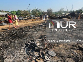 Residents walk pass by their charred house after an inferno on the night of Diwali, the Hindu Festival of Light celebration, which gutted do...