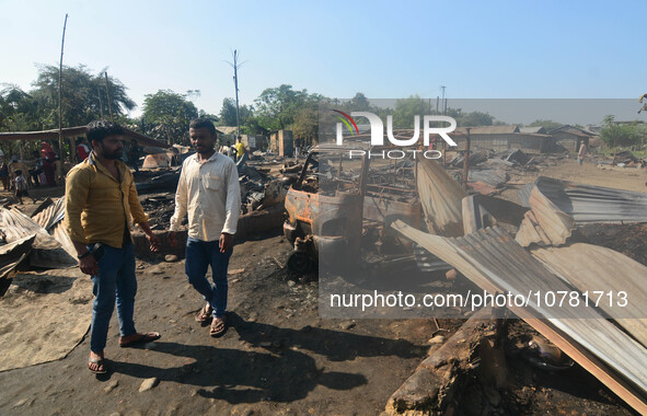 Residents walk pass by their charred house after an inferno on the night of Diwali, the Hindu Festival of Light celebration, which gutted do...