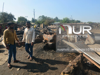 Residents walk pass by their charred house after an inferno on the night of Diwali, the Hindu Festival of Light celebration, which gutted do...