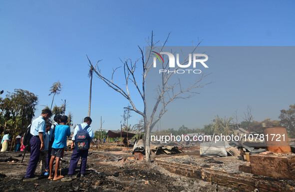 School student looks on in between charred house after an inferno on the night of Diwali, the Hindu Festival of Light celebration, which gut...