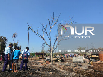 School student looks on in between charred house after an inferno on the night of Diwali, the Hindu Festival of Light celebration, which gut...