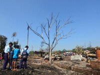 School student looks on in between charred house after an inferno on the night of Diwali, the Hindu Festival of Light celebration, which gut...