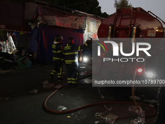 Firefighters get ready to put out a fire in the shoe market in Tepito, Historic Center of Mexico City. (