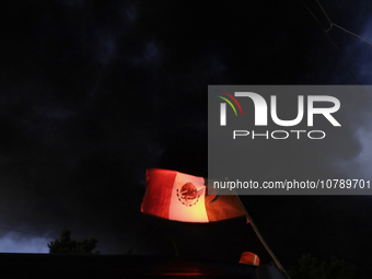 View of a Mexican flag in front of smoke after a fire in the shoe market in Tepito, Historic Center of Mexico City. (