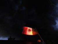 View of a Mexican flag in front of smoke after a fire in the shoe market in Tepito, Historic Center of Mexico City. (