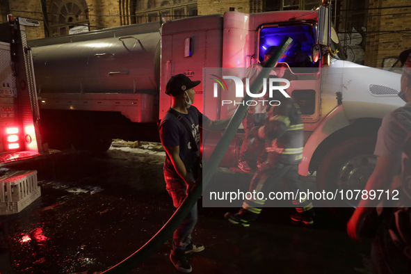 Firefighters and merchants coordinate to put out a fire in the shoe market in Tepito, Historic Center of Mexico City. 