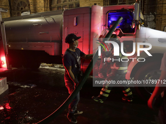 Firefighters and merchants coordinate to put out a fire in the shoe market in Tepito, Historic Center of Mexico City. (