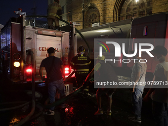 Firefighters and merchants coordinate to put out a fire in the shoe market in Tepito, Historic Center of Mexico City. (