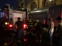 Firefighters and merchants coordinate to put out a fire in the shoe market in Tepito, Historic Center of Mexico City. (