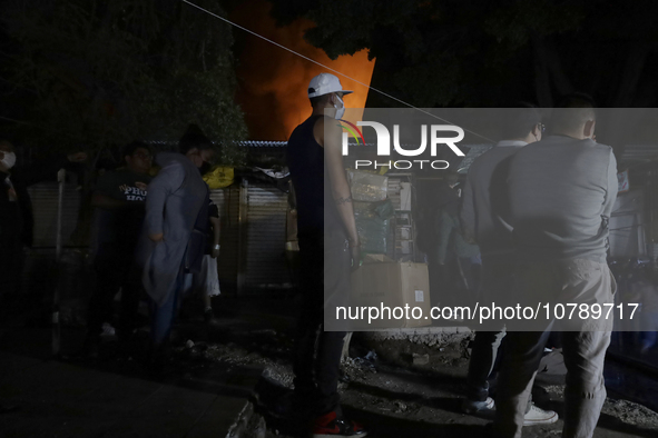 Merchants try to help firefighters with hoses to put out a fire in the shoe market in Tepito, Historic Center of Mexico City. 