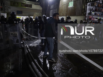 Merchants help firefighters with hoses to put out a fire in the shoe market in Tepito, Historic Center of Mexico City. (