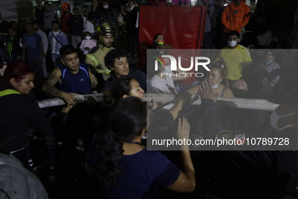 Merchants help firefighters with hoses to put out a fire in the shoe market in Tepito, Historic Center of Mexico City. 