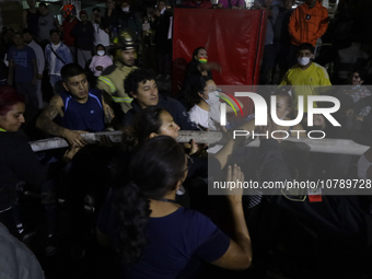 Merchants help firefighters with hoses to put out a fire in the shoe market in Tepito, Historic Center of Mexico City. (