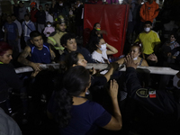 Merchants help firefighters with hoses to put out a fire in the shoe market in Tepito, Historic Center of Mexico City. (