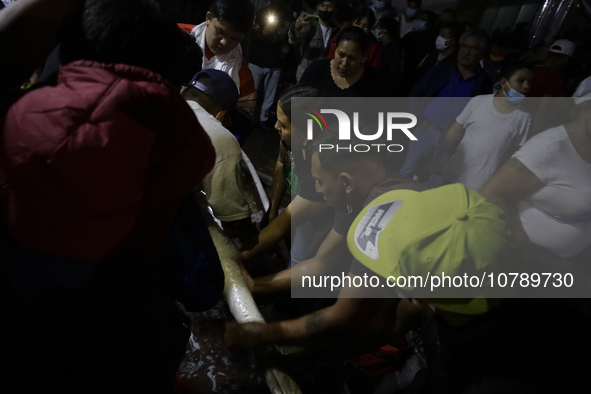 Merchants help firefighters with hoses to put out a fire in the shoe market in Tepito, Historic Center of Mexico City. 