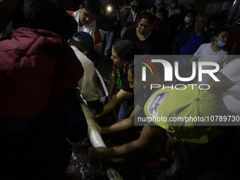 Merchants help firefighters with hoses to put out a fire in the shoe market in Tepito, Historic Center of Mexico City. (