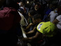 Merchants help firefighters with hoses to put out a fire in the shoe market in Tepito, Historic Center of Mexico City. (