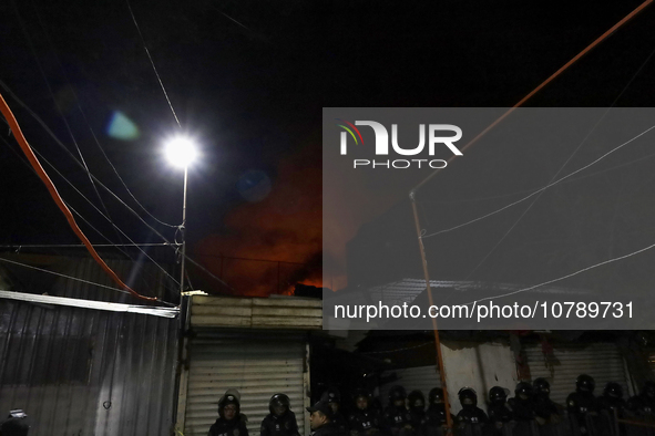 Below, police protect the area after a fire in the shoe market in Tepito, Historic Center of Mexico City. 