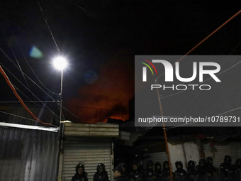 Below, police protect the area after a fire in the shoe market in Tepito, Historic Center of Mexico City. (