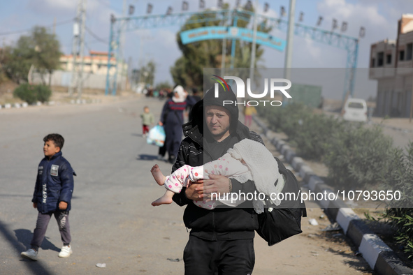 Palestinians fleeing Gaza City and other parts of northern Gaza, carry some belongings as they walk along a road leading to the southern are...