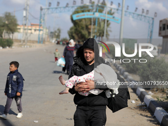 Palestinians fleeing Gaza City and other parts of northern Gaza, carry some belongings as they walk along a road leading to the southern are...