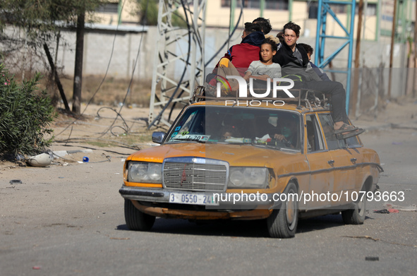 Palestinians fleeing Gaza City and other parts of northern Gaza, carry some belongings as they walk along a road leading to the southern are...