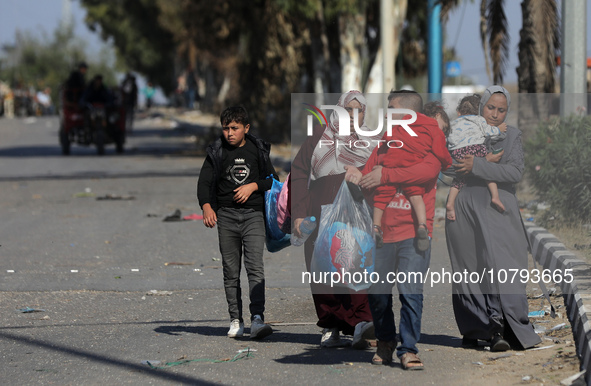 Palestinians fleeing Gaza City and other parts of northern Gaza, carry some belongings as they walk along a road leading to the southern are...