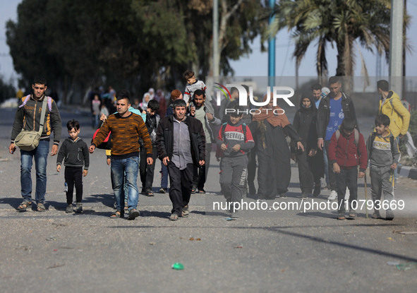 Palestinians fleeing Gaza City and other parts of northern Gaza, carry some belongings as they walk along a road leading to the southern are...