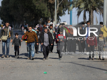 Palestinians fleeing Gaza City and other parts of northern Gaza, carry some belongings as they walk along a road leading to the southern are...