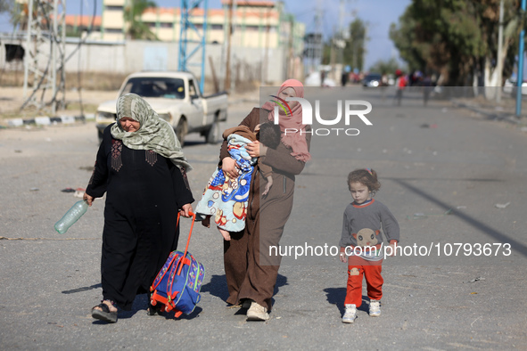 Palestinians fleeing Gaza City and other parts of northern Gaza, carry some belongings as they walk along a road leading to the southern are...