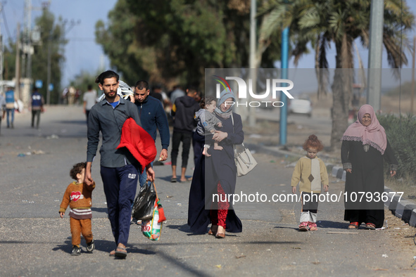 Palestinians fleeing Gaza City and other parts of northern Gaza, carry some belongings as they walk along a road leading to the southern are...