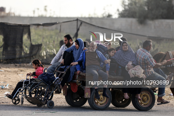 Palestinians fleeing Gaza City and other parts of northern Gaza, carry some belongings as they walk along a road leading to the southern are...