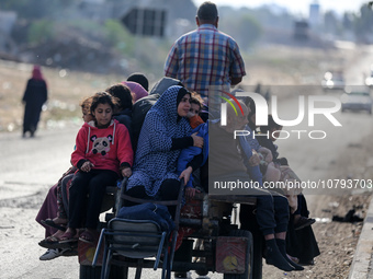 Palestinians fleeing Gaza City and other parts of northern Gaza, carry some belongings as they walk along a road leading to the southern are...