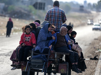 Palestinians fleeing Gaza City and other parts of northern Gaza, carry some belongings as they walk along a road leading to the southern are...