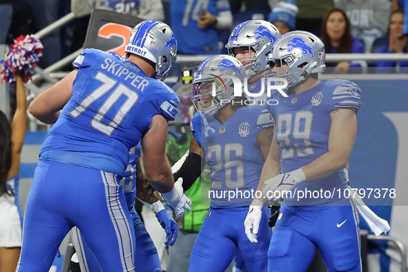 Detroit Lions running back Jahmyr Gibbs (26) is congratulated by teamates after scoring a touchdown during the first half of an NFL football...