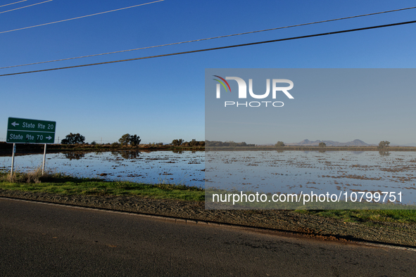 The sun rises over flooded California rice fields, during a storm break brought on by an atmospheric river near Marysville, Calif., on Sunda...